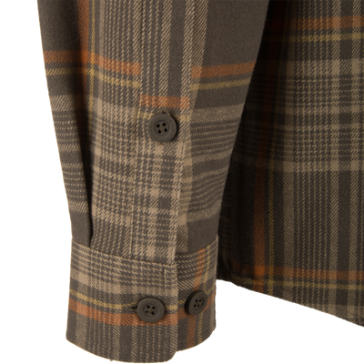 Close-up of the Legacy Flannel Plaid Shirt showing cuff and front panel details with branded “DRAKE” buttons, highlighting its rugged yet refined design.