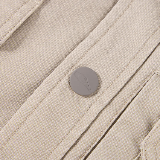 Close-up of Campfire Canvas Shirt Jac Hoodie, showcasing beige canvas fabric, stitched seams, and embossed snap-button detail, emphasizing its durable, workwear-inspired design.