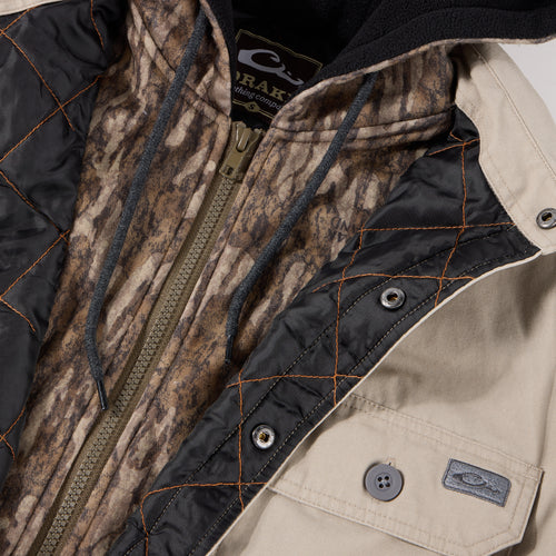 Campfire Canvas Shirt Jac Hoodie featuring a camo zip-up hoodie layered under a tan canvas jacket with quilted lining and snap closures, showcasing casual workwear-inspired design.