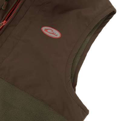 Close-up of the Drake Eqwader Vest showcasing its waterproof upper with taped seams, fleece lower body, and chest pockets designed for secure storage.