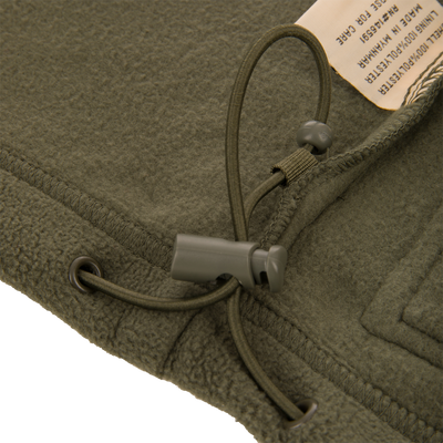 Eqwader Vest with close-up of button and green fleece, showcasing Magnattach™ chest pocket and waterproof Refuge HS™ upper body for versatile hunting functionality.