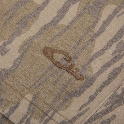 Close-up of Drake Tri Blend Campus Short, showcasing camo-patterned fabric with a stitched seam and embroidered logo, highlighting its soft, stretchable, quick-drying material.