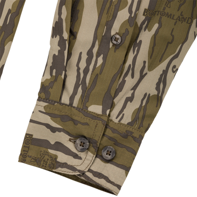 Close-up of Drake Youth Long-Sleeved Flyweight Camo Hunting Shirt, highlighting branded buttons and camo pattern, showcasing technical features like moisture-wicking and sun protection.