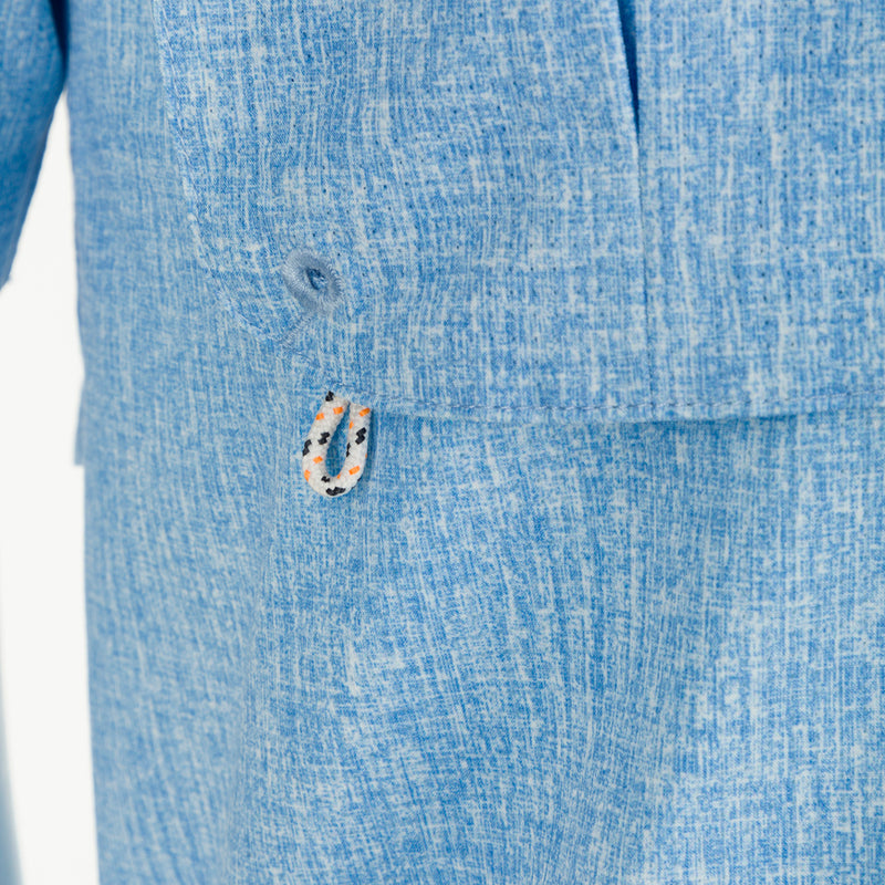 Heritage Heather Shirt S/S: A close-up of a blue suit with a hidden button-down collar, vented cape back, and two front chest pockets.