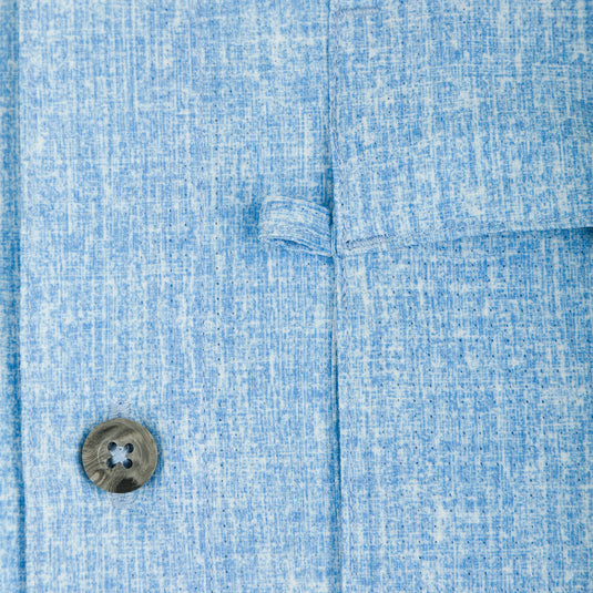 Heritage Heather Shirt S/S: A button on a blue shirt, close up.