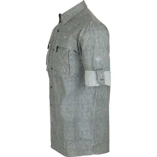 Heritage Heather Shirt L/S: A close-up of a grey shirt with a button and chest pockets. Classic styling and performance features for any occasion.