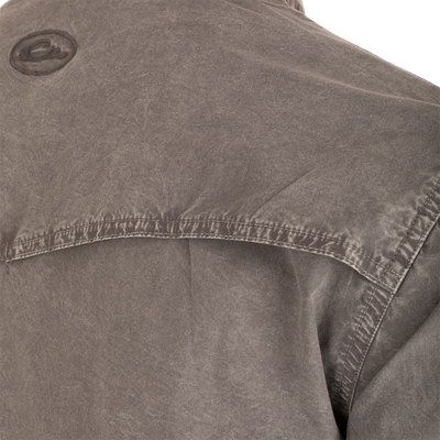 Close-up of the Cinco Ranch Western Solid Acid Wash Long Sleeve Shirt's upper back, highlighting the center seam, yoke flap, and embroidered patch.