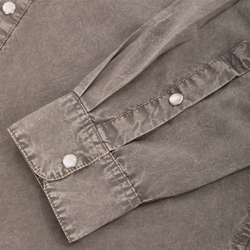 Close-up of the Cinco Ranch Western Solid Acid Wash Long Sleeve Shirt's cuff, showcasing the faux pearl snap buttons and stitched placket detail.