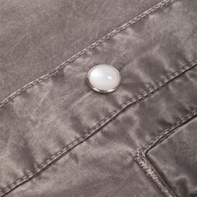 Close-up of Cinco Ranch Western Solid Acid Wash Long Sleeve Shirt, showcasing textured fabric with top-stitching and a metal snap button on a pocket detail.