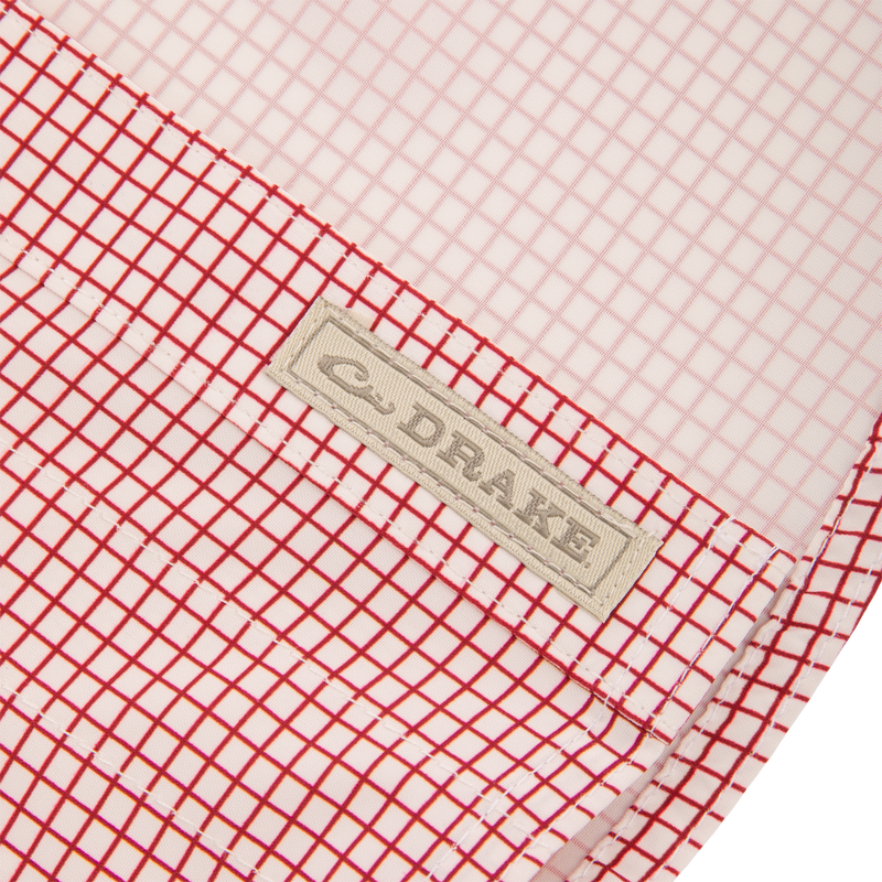 Close-up of the Wingshooters Trey Grid Check Short Sleeve Shirt highlighting the red-and-white grid fabric with “DRAKE” label, showcasing its performance features.
