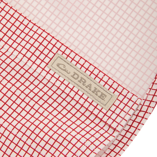 Close-up of the Wingshooters Trey Grid Check Short Sleeve Shirt highlighting the red-and-white grid fabric with “DRAKE” label, showcasing its performance features.
