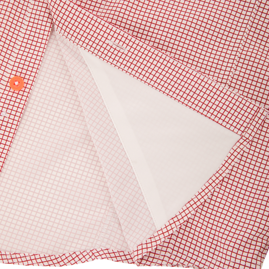 Close-up of the Drake Wingshooter Trey Grid Check Shirt's front placket, highlighting the orange button and inner interfacing layer for technical performance.