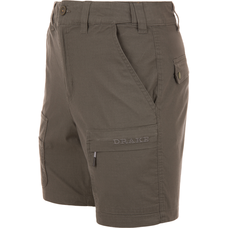 Olive-green 9 Pocket Ripstop Short on mannequin, featuring multiple pockets, including zip and flap, with elastic waistband, ideal for outdoor adventures.