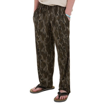 Drake Lounge Pant in camouflage, featuring an elastic drawstring waist and side pockets, styled with flip-flops and a silicone wristband.