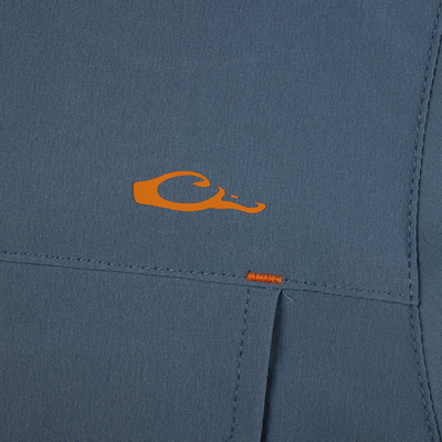 Lake Shore Performance Short Sleeve Shirt featuring an orange letter detail on blue fabric, highlighting its stretch, moisture-wicking capabilities, and vented cape back design.