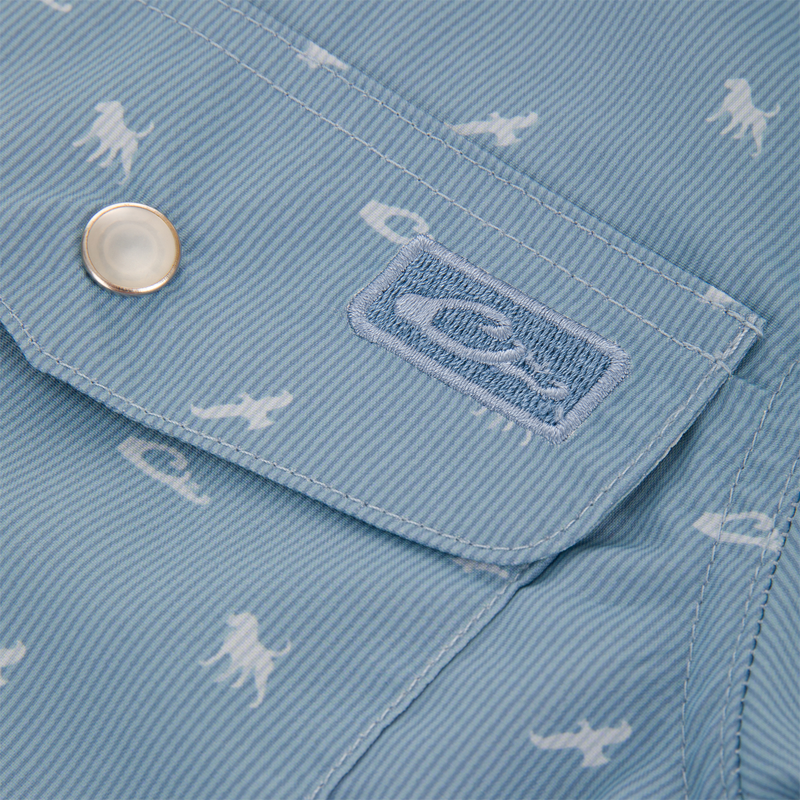 Cinco Ranch Western Short Sleeve Shirt flap, featuring a metal snap and embroidered logo, with sea creature print on light-blue, fine-striped fabric.