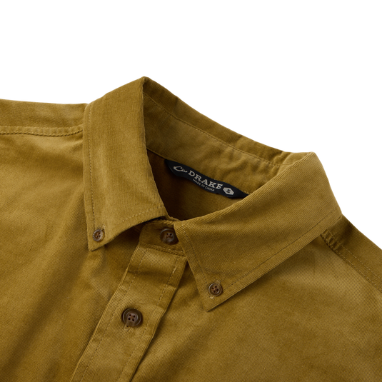Close-up of the Midwale Corduroy Shirt collar and buttons, showcasing the mustard-yellow corduroy fabric with stretch for comfort, labeled DRAKE, size S.