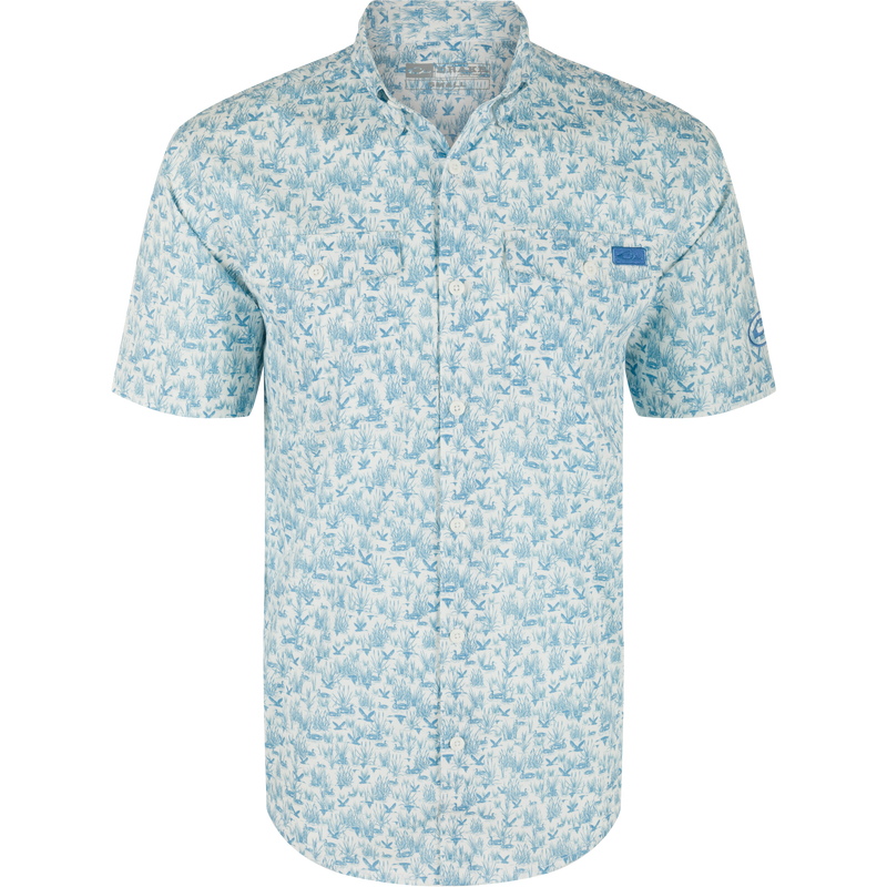 Cotton Marsh Print Short Sleeve Shirt featuring light-blue nature print, button-down collar, chest pockets, and sculpted hem, displayed on a hanger, embodying Drake Waterfowl's casual style.