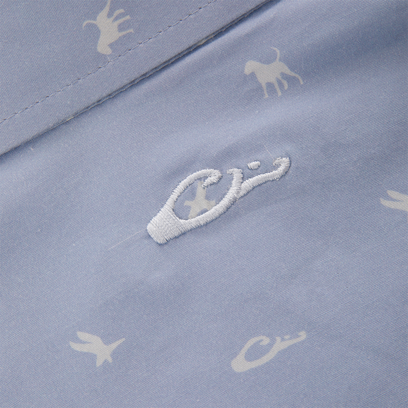 Close-up of the Cotton DDD Print Shirt, showcasing tiny white animal silhouettes and a central embroidered logo on pale blue fabric, reflecting Drake Waterfowl's signature casual style.