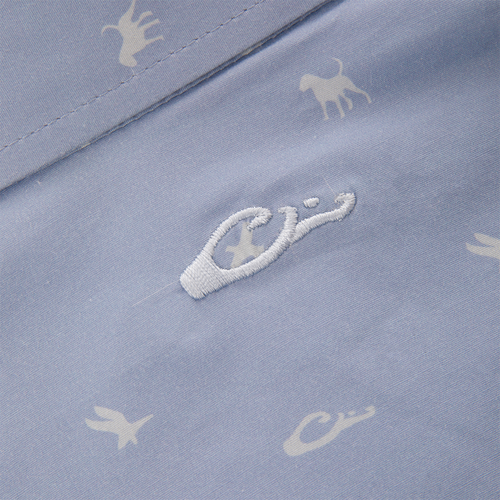 Close-up of the Cotton DDD Print Shirt, showcasing tiny white animal silhouettes and a central embroidered logo on pale blue fabric, reflecting Drake Waterfowl's signature casual style.