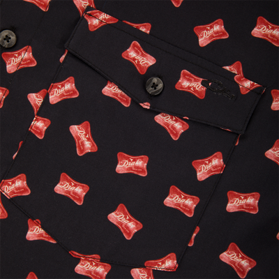 Close-up of Cotton Drake Life Print Short Sleeve Shirt, featuring red Drake logo pattern, flap pocket with button, and visible stitched seams.
