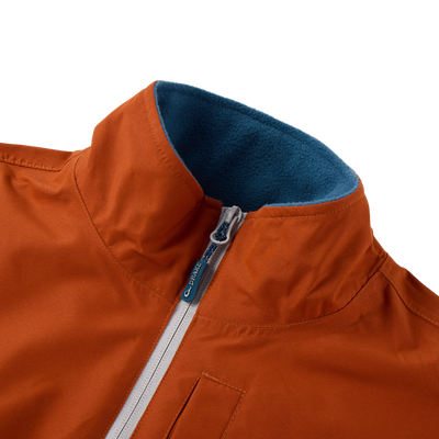 Eqwader Half Zip Pullover with rust-orange waterproof fabric, teal fleece-lined collar, light-gray zipper with Drake logo, and visible welt pocket for hunting comfort.