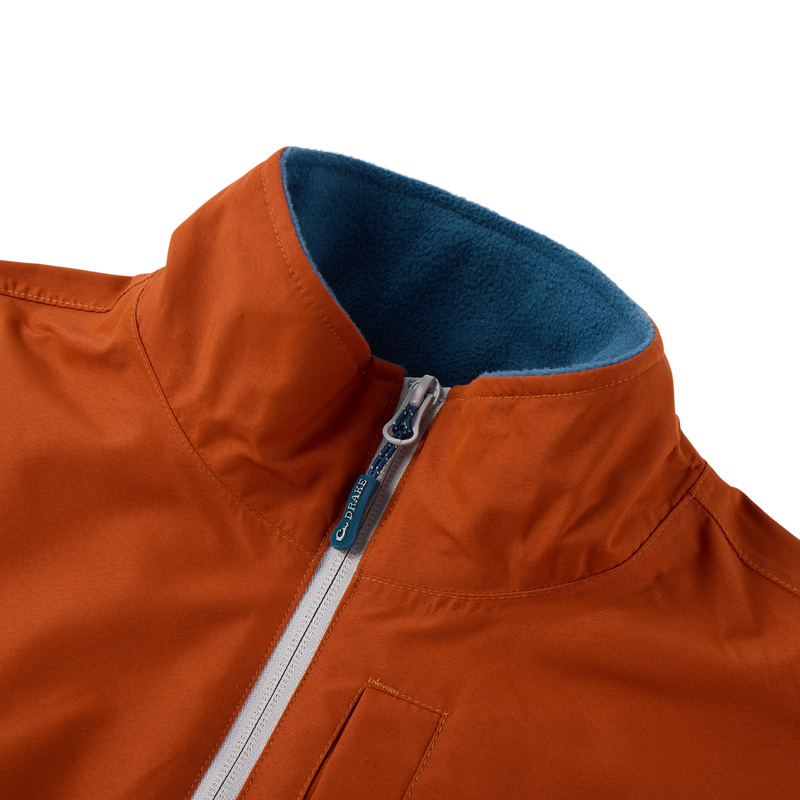 Eqwader Half Zip Pullover with rust-orange waterproof fabric, teal fleece-lined collar, light-gray zipper with Drake logo, and visible welt pocket for hunting comfort.