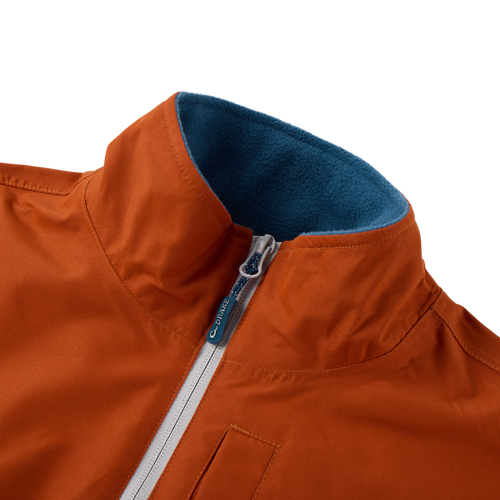 Eqwader Half Zip Pullover with rust-orange waterproof fabric, teal fleece-lined collar, light-gray zipper with Drake logo, and visible welt pocket for hunting comfort.