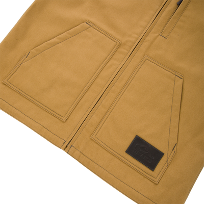 Lifestyle Canvas Sherpa Lined Work Vest in tan, featuring a zipper closure, two front patch pockets, and a rectangular branded patch on the lower right pocket.