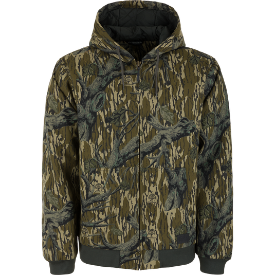 Lifestyle Duck Canvas Work Jacket in a Mossy Oak Original Treestand camouflage pattern, featuring a zip-up hood, insulation, and black rib-knit cuffs and hem.