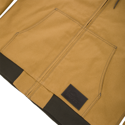 Lifestyle Duck Canvas Work Jacket in tan with a front zipper, large pouch pocket, and a dark brown ribbed waistband featuring a rectangular logo patch.