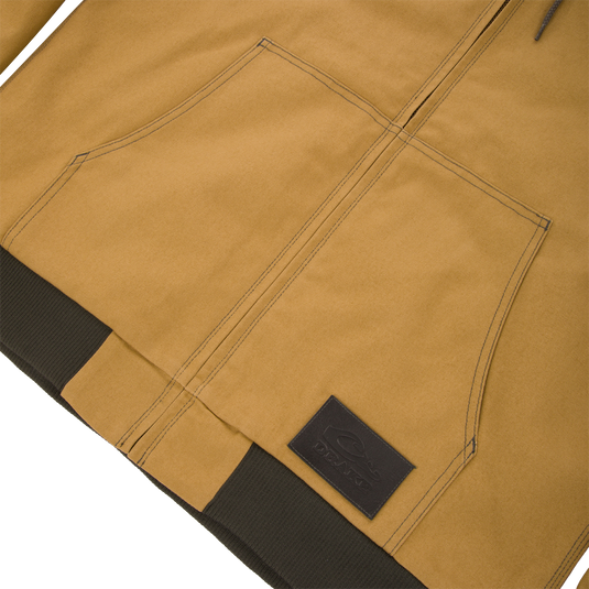 Lifestyle Duck Canvas Work Jacket in tan with a front zipper, large pouch pocket, and a dark brown ribbed waistband featuring a rectangular logo patch.