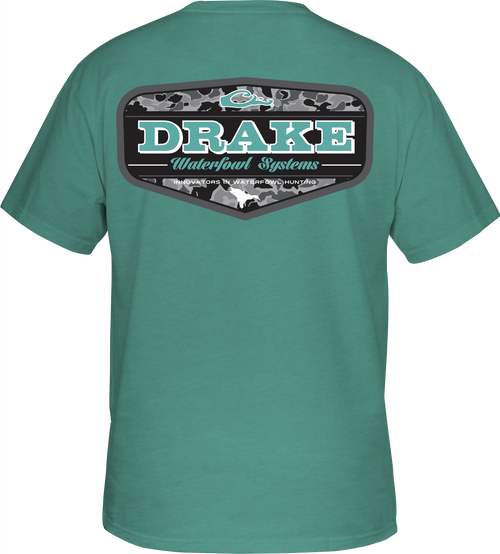 A green Old School Badge T-Shirt with a Drake logo on the front pocket. Made of a cotton/polyester blend for softness and comfort.