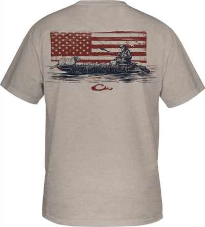 Kayak Flag T-Shirt featuring a man in a canoe with a dog and American flag graphic, part of Drake's Americana Series, known for hunting gear.