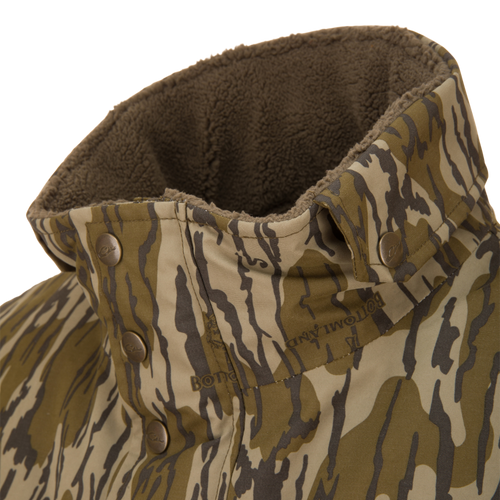 Close-up of the Throwback 80 Insulated Sport Bomber Jacket's collar showing tiger-stripe camo pattern, metal snap buttons, and visible brown sherpa lining.