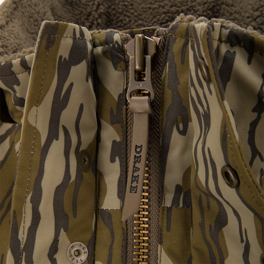Throwback 80 Insulated Sport Bomber Jacket with camouflage print, metal YKK zipper, leather DRAKE pull, snap-button storm flap, and fleece lining peeking out.