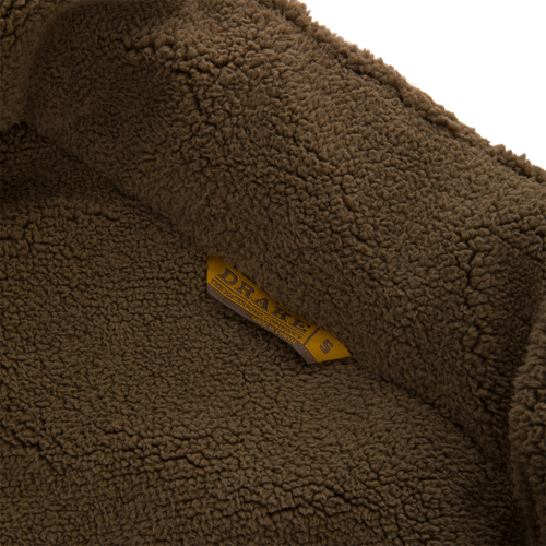 Close-up of the Throwback 80 Sport Vest's soft sherpa fleece lining with a DRAKE size tag, highlighting its warmth and comfort features for outdoor adventures.