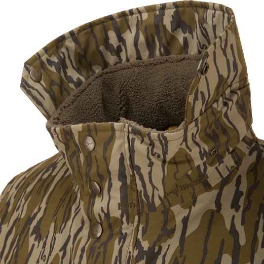 Close-up of the Throwback 80 Sport 3-in-1 Jacket's collar, showcasing tiger-stripe camo pattern, fleece lining, and metal snap buttons for outdoor versatility.
