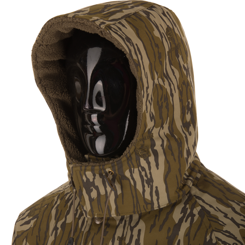 Camouflage-patterned Throwback 80 Sport 3-in-1 Jacket with hood, fleece lining, and accessory pockets, ideal for all-weather protection and outdoor adventures.