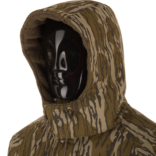 Camouflage-patterned Throwback 80 Sport 3-in-1 Jacket with hood, fleece lining, and accessory pockets, ideal for all-weather protection and outdoor adventures.