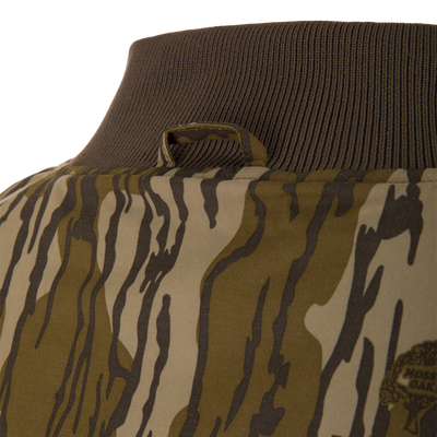 Close-up of the Throwback 80 Sport 3-in-1 Jacket's camo-patterned back, showcasing the ribbed knit collar and hanging loop, ideal for outdoor adventures.