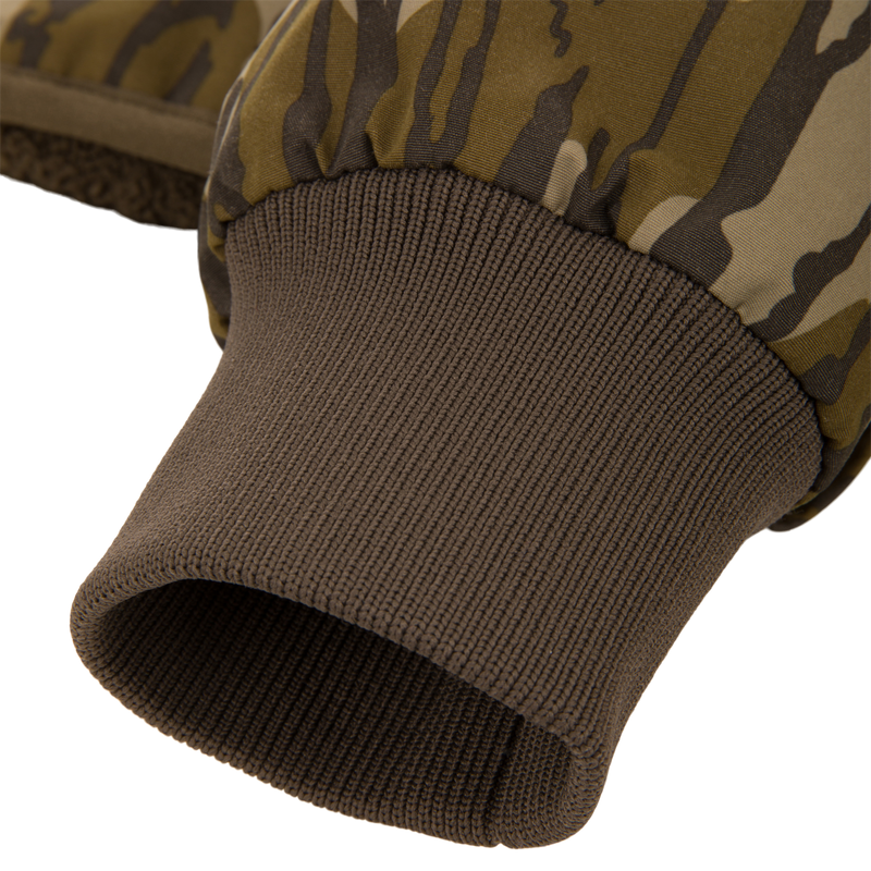 Close-up of a camo-patterned mitten's wrist area, showcasing the fleece lining and ribbed knit cuff, part of the Throwback 80 Sport 3-in-1 Jacket ensemble.
