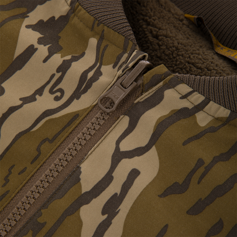 Close-up of Throwback 80 Sport 3-in-1 Jacket featuring tiger-stripe camo, YKK zipper, rib-knit collar, and fleece lining for warmth and weather protection.