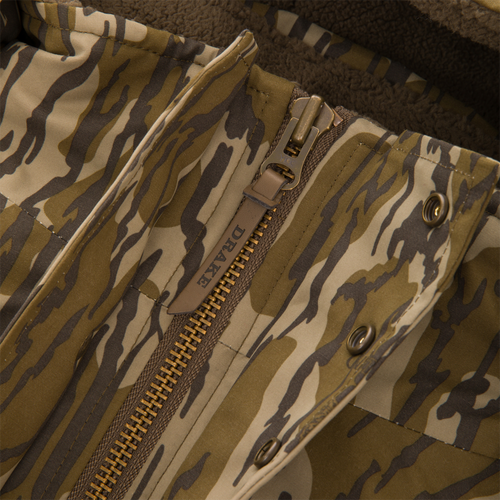 Close-up of the Throwback 80 Sport 3-in-1 Jacket's front placket, featuring a heavy-duty zipper, snap-fasteners, and tiger-stripe camouflage fabric with sherpa fleece lining.