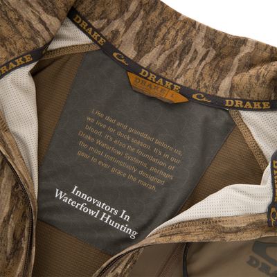 EST Offset 1.0 Half Zip Pullover interior showing Drake logo, fabric label with brand ethos, cooling technology, UPF30 protection, ergonomic thumbholes, and YKK zipper for hunting comfort.
