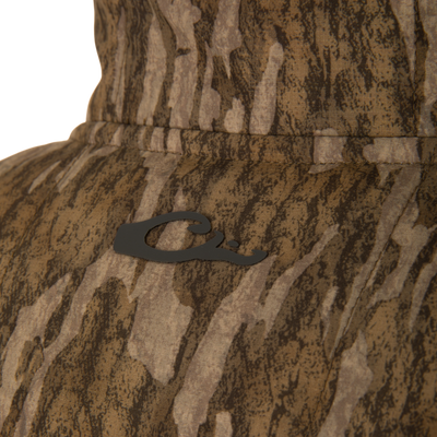 Close-up of LST BMF Jacket with Primaloft, showing camo-patterned fabric, a black Q emblem, and detailed stitching, highlighting its durable, water-resistant ripstop material.