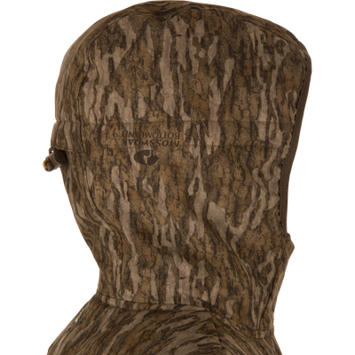 Close-up side view of LST BMF Jacket with Primaloft, showcasing a camouflage-patterned hood with adjustable draw-cord toggle and Mossy Oak Bottomland print.