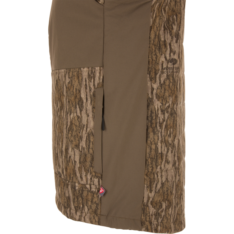 LST BMF Jacket with Primaloft in Mossy Oak Bottomland camo, featuring a vertical zippered pocket, PrimaLoft tag, and durable, water-resistant stretch fabric.