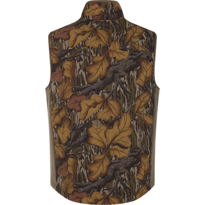 Back view of a Drake X Ducks Unlimited LST BMF Vest with Primaloft featuring a brown and green camouflage pattern of oak leaves and branches.