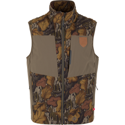 Zip-up Drake X Ducks Unlimited LST BMF Vest with Primaloft in Mossy Oak Fall Foliage, featuring a leaf-print camouflage pattern with solid olive panels on the chest and a leather logo patch on the upper left.